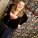 A plump, blonde girl is video-recorded peeing while sitting on a toilet by her friend.